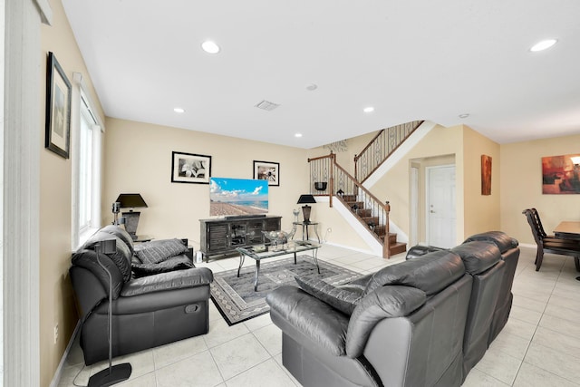 living room with light tile patterned floors, recessed lighting, visible vents, and stairway