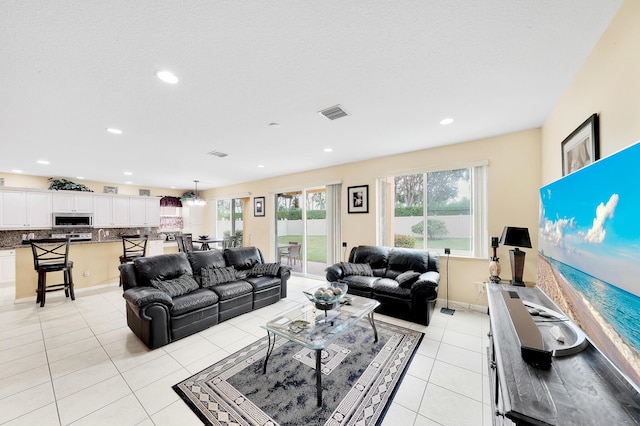 living room featuring visible vents, light tile patterned floors, and recessed lighting