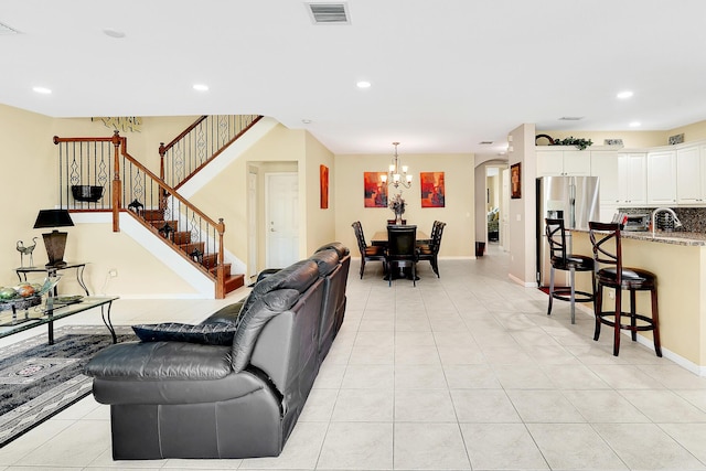 living area featuring recessed lighting, stairs, visible vents, and a chandelier