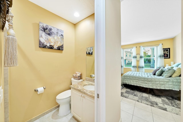 bathroom with toilet, vanity, ensuite bathroom, and tile patterned flooring