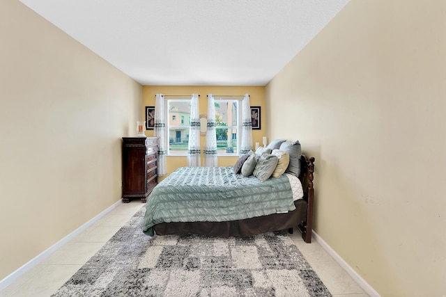 bedroom featuring light tile patterned floors and baseboards