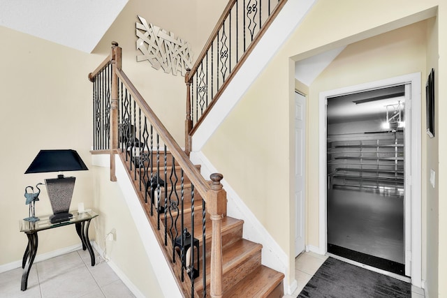 stairs featuring baseboards and tile patterned flooring