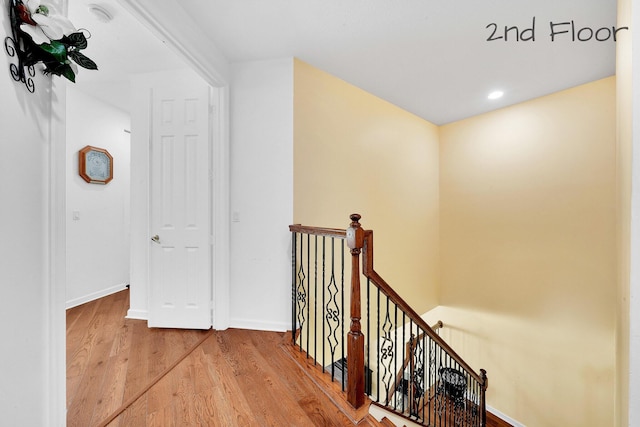 corridor featuring recessed lighting, an upstairs landing, wood finished floors, and baseboards