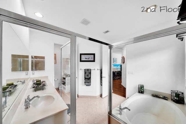 bathroom featuring double vanity, visible vents, a bath, and a sink