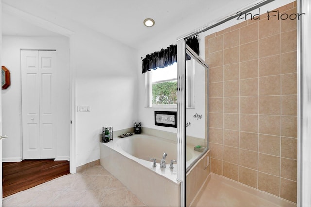bathroom with recessed lighting, a shower stall, a bath, baseboards, and tile patterned flooring