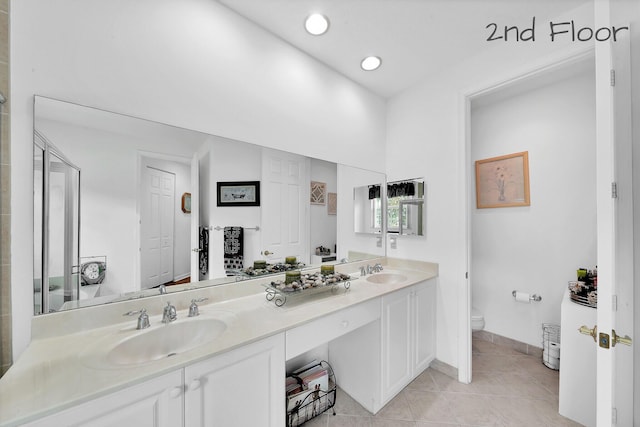 full bath featuring double vanity, toilet, tile patterned flooring, and a sink