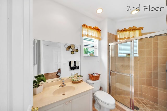 bathroom featuring a stall shower, toilet, and vanity