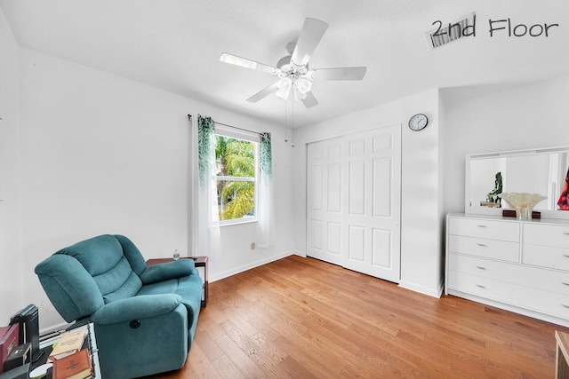 sitting room with ceiling fan, light wood finished floors, and baseboards