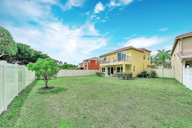 view of yard with a fenced backyard and a balcony