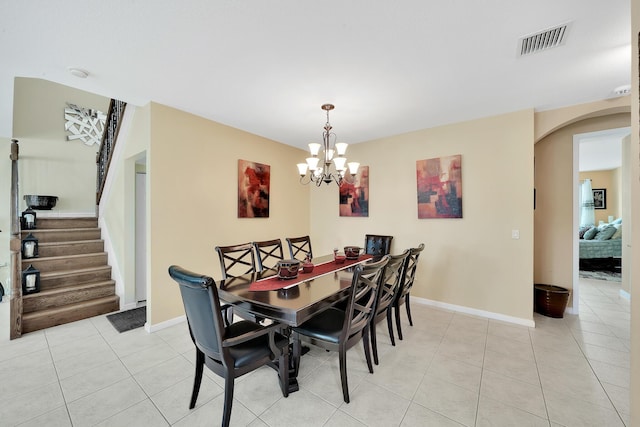 dining room with arched walkways, a chandelier, light tile patterned floors, baseboards, and visible vents