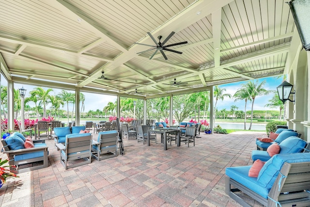 view of patio with outdoor lounge area, outdoor dining space, a ceiling fan, and a water view