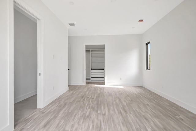 interior space with light wood-style floors, baseboards, and visible vents