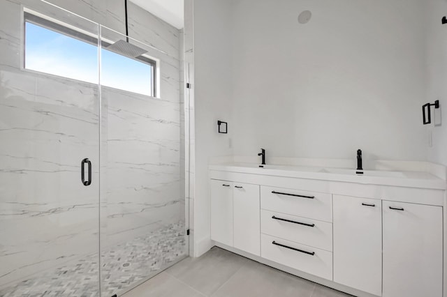 full bathroom featuring double vanity, a marble finish shower, and a sink