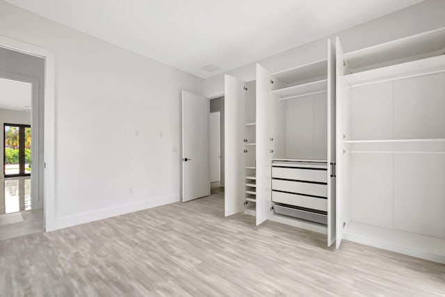 unfurnished bedroom with a closet, baseboards, and wood finished floors