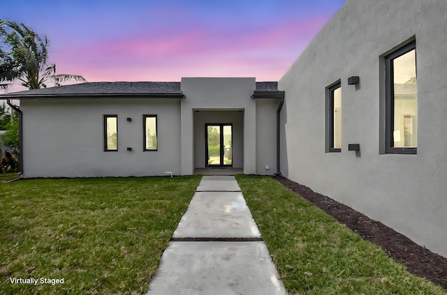 view of front facade with a yard and stucco siding