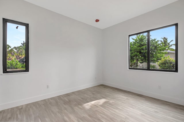 spare room featuring light wood finished floors and baseboards