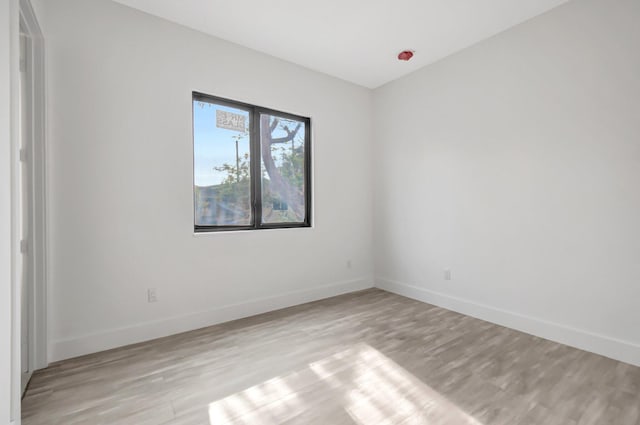 unfurnished room with baseboards and light wood finished floors