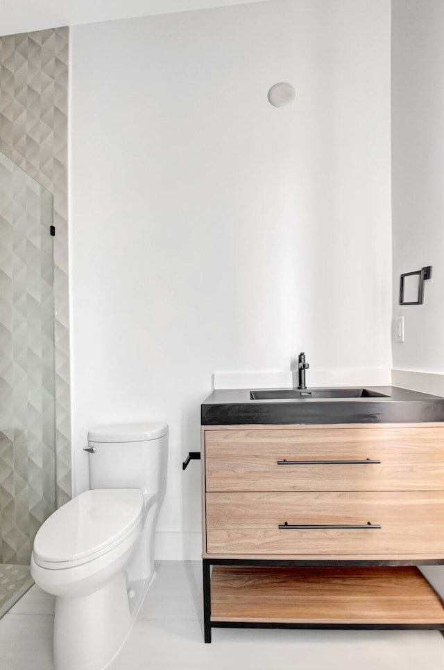 bathroom featuring a shower stall, vanity, baseboards, and toilet