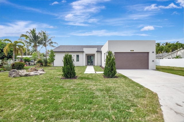 view of front facade with a garage, stucco siding, concrete driveway, and a front lawn