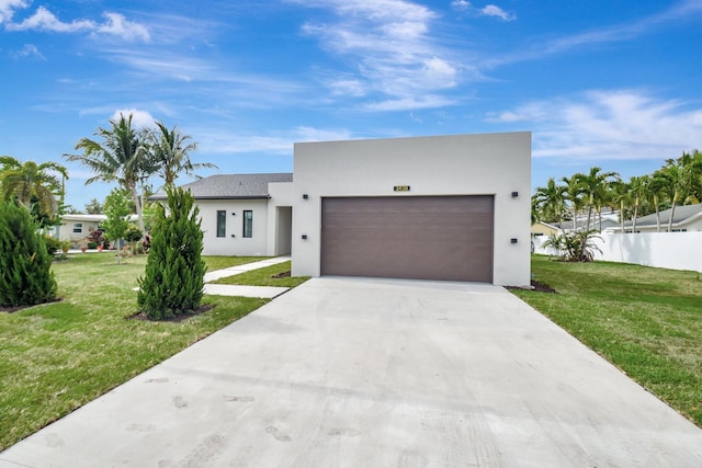 contemporary home with concrete driveway, stucco siding, an attached garage, a front lawn, and fence