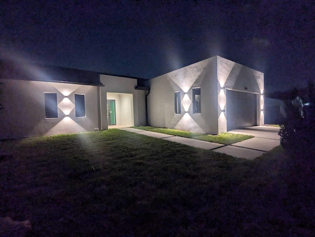 view of front of house with a yard and stucco siding