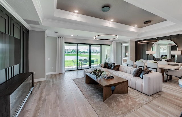 10734 Stellar Cir Unit Stardom 9, Palm Beach Gardens, FL 33412 - living room with a raised ceiling, light wood-style flooring, baseboards, and crown molding