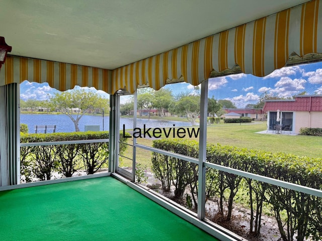 sunroom featuring a water view