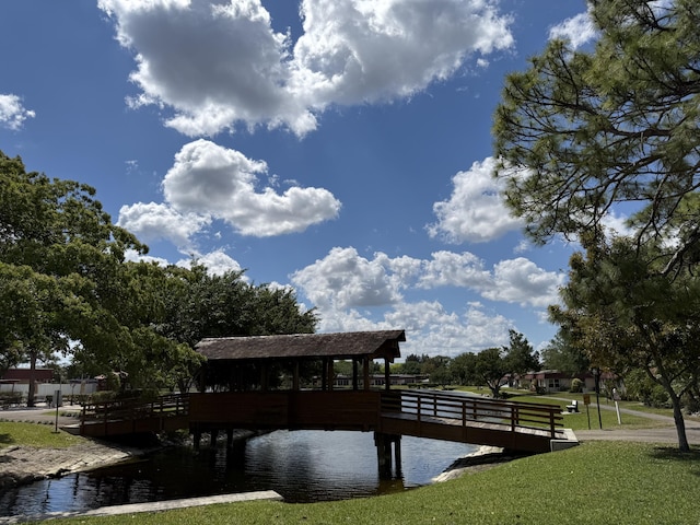 view of dock with a lawn and a water view