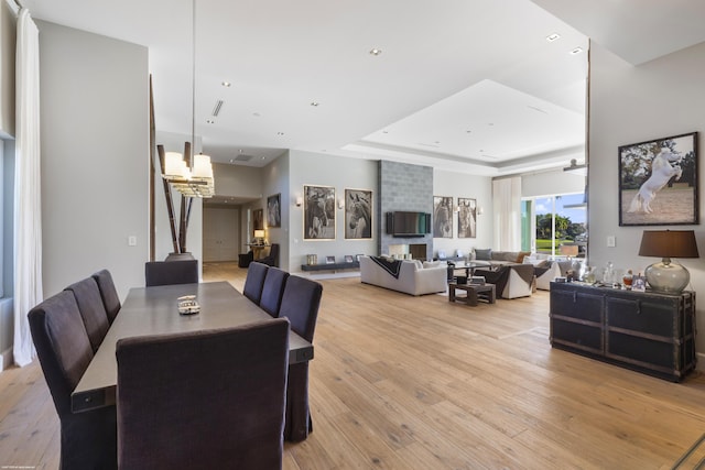 dining room with light wood-style flooring, a tray ceiling, and recessed lighting