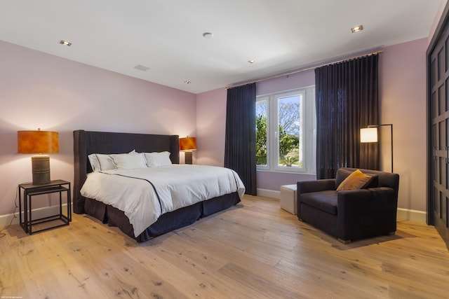 bedroom with baseboards and light wood finished floors