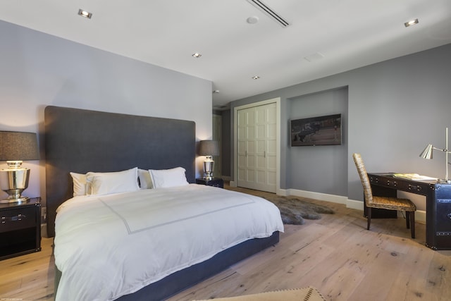 bedroom featuring baseboards, wood finished floors, and a closet