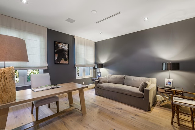 living room featuring light wood-style flooring and visible vents