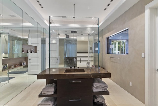 bathroom with tile patterned flooring and a tray ceiling
