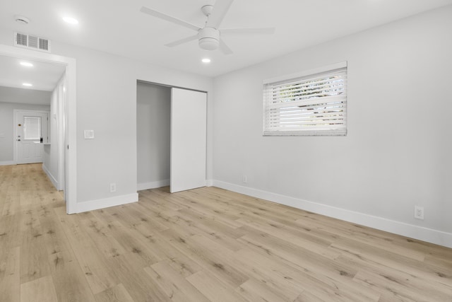 unfurnished bedroom with baseboards, visible vents, light wood finished floors, and a closet