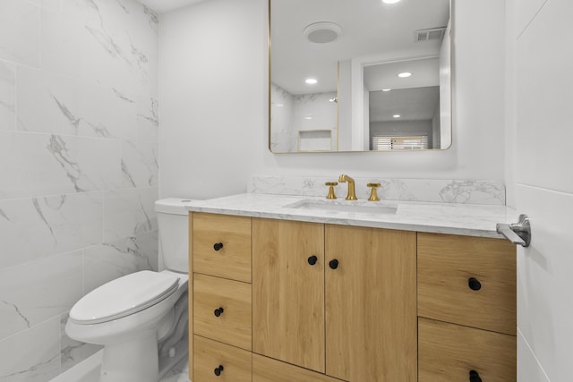 bathroom with recessed lighting, vanity, toilet, and visible vents