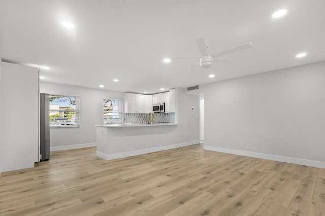 unfurnished living room with a ceiling fan, visible vents, light wood-type flooring, baseboards, and recessed lighting
