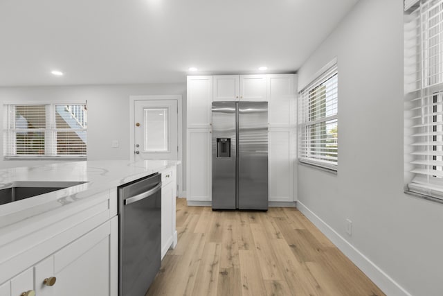 kitchen featuring light stone countertops, stainless steel appliances, recessed lighting, and white cabinetry