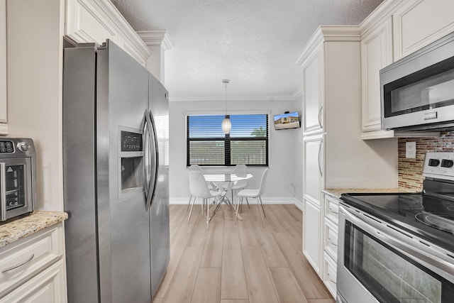 kitchen with baseboards, appliances with stainless steel finishes, white cabinets, and light wood-type flooring