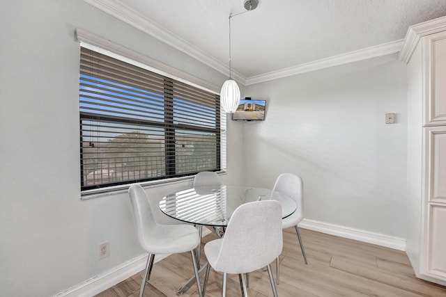 dining area with light wood-style floors, baseboards, and ornamental molding