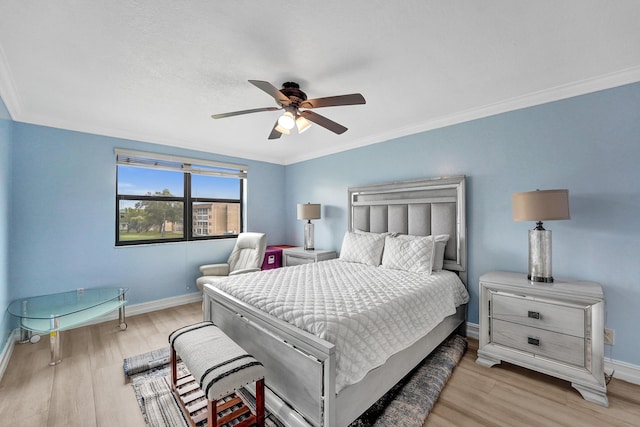 bedroom with baseboards, ornamental molding, ceiling fan, and wood finished floors