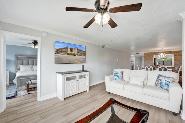 living area featuring ceiling fan, baseboards, wood finished floors, visible vents, and ornamental molding