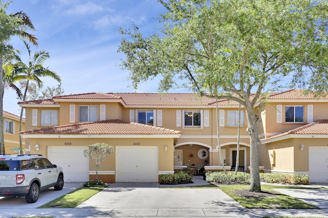 6170 Sugar Loaf Ln, West Palm Beach, FL 33411 - view of front facade featuring a tile roof, concrete driveway, a garage, and stucco siding