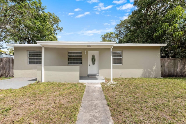 1134 NW 18th Ave, Fort Lauderdale, FL 33311 - view of front of property featuring stucco siding, fence, and a front lawn