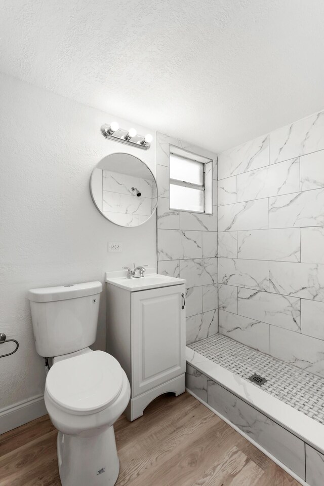 1134 NW 18th Ave, Fort Lauderdale, FL 33311 - full bath with vanity, a tile shower, toilet, a textured ceiling, and wood finished floors