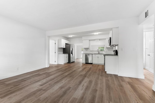 1134 NW 18th Ave, Fort Lauderdale, FL 33311 - unfurnished living room with visible vents, baseboards, and wood finished floors