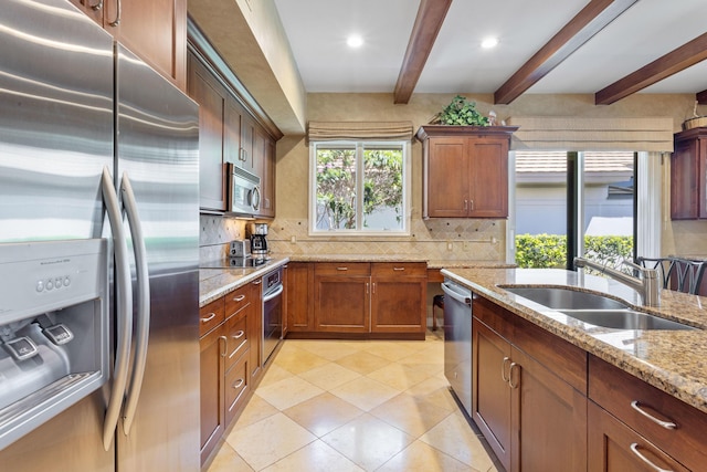 kitchen featuring beamed ceiling, decorative backsplash, a sink, and appliances with stainless steel finishes