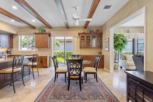 dining area with light tile patterned flooring, baseboards, visible vents, beamed ceiling, and a ceiling fan