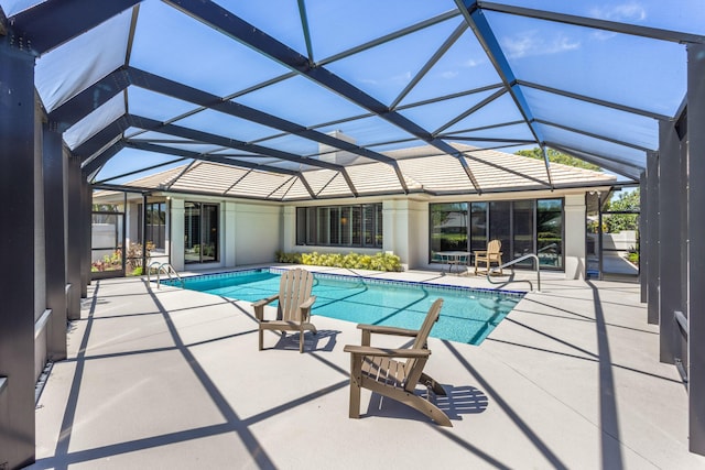 outdoor pool with glass enclosure and a patio area