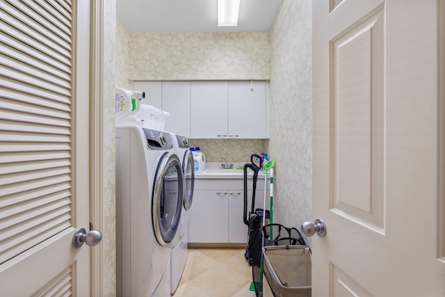 clothes washing area with separate washer and dryer, cabinet space, and wallpapered walls