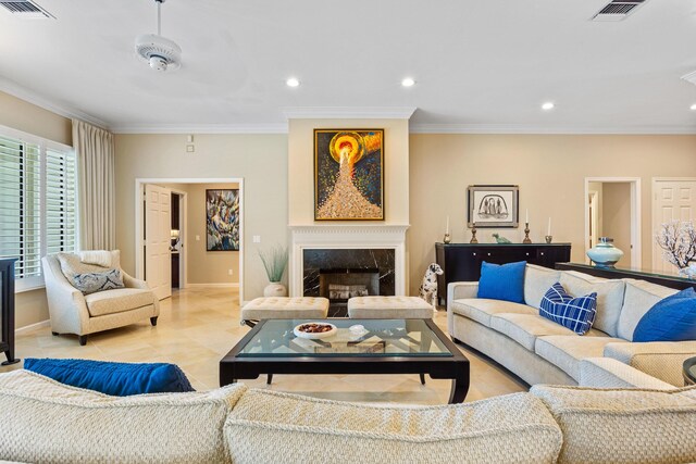 living area with visible vents, baseboards, and ornamental molding